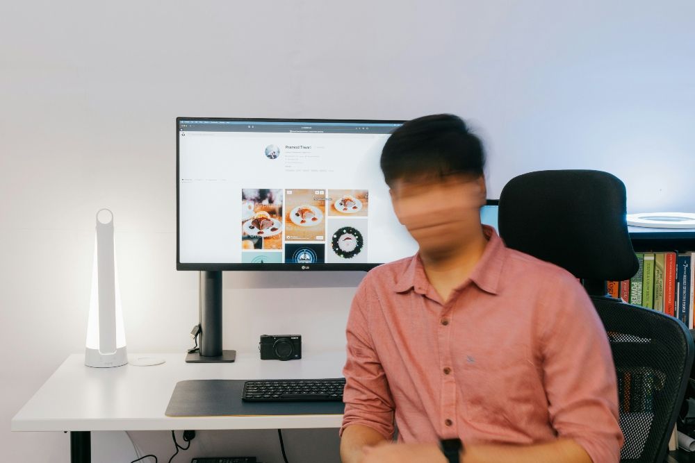 Persona desenfocada frente a un monitor con contenido multimedia, representando la confusión entre realidad y manipulación digital.